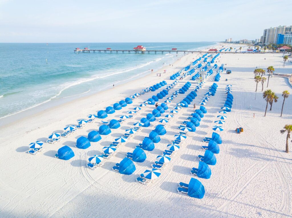 a view of the beach looking north. White sand, blue umbrellas and clean water in the Gulf of Mexico