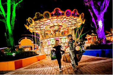 Kids trick or treating in front of carousel at LEGOLAND Florida at night- our favorite places for Halloween
